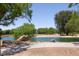 A serene pond is framed by lush greenery, rock accents, and a paved path, enhancing the community's beauty at 5935 Saddle Horse Ave, Las Vegas, NV 89122