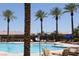 Relaxing pool area with multiple lounge chairs and towering palm trees at Solera at Stallion Mountain at 5935 Saddle Horse Ave, Las Vegas, NV 89122