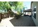 Gravel backyard with covered patio, mature tree and privacy fence at 6040 Eganridge Ct, North Las Vegas, NV 89081
