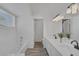 Bright bathroom featuring double sinks, quartz countertop, and modern lighting fixtures at 6112 Blossom Knoll Ave, Las Vegas, NV 89108