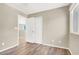 Neutral-toned bedroom boasts wood-look floors, a window, and closet with doors ajar at 636 Pacific Cascades Dr, Henderson, NV 89012