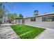 Spacious backyard with artificial turf, gravel landscaping, and a covered patio at 6517 Villa Mesa Dr, Las Vegas, NV 89107