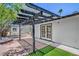 Backyard features black pergola, artificial grass, and brick-lined gravel at 6517 Villa Mesa Dr, Las Vegas, NV 89107