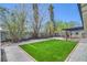 Wide shot of the backyard featuring turf, gravel, and drought-tolerant plants at 6517 Villa Mesa Dr, Las Vegas, NV 89107