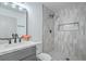 Well-lit bathroom features gray and white tiling and includes vanity and glass-enclosed shower at 6517 Villa Mesa Dr, Las Vegas, NV 89107