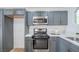 Close-up of updated kitchen features stainless steel appliances, gray cabinets, and quartz countertops at 6517 Villa Mesa Dr, Las Vegas, NV 89107