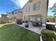 A view of a backyard with a dining set under a pergola, a grill, and lush green grass at 6682 Salt Pond Bay St, Las Vegas, NV 89149