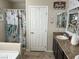 Bathroom features include a granite vanity top, tropical-themed shower curtain, and neutral decor at 6682 Salt Pond Bay St, Las Vegas, NV 89149