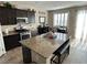 Well-appointed kitchen featuring dark cabinetry, a granite island with seating, and modern appliances at 6682 Salt Pond Bay St, Las Vegas, NV 89149