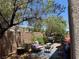 Backyard featuring mature trees, patio seating and lush landscaping, creating a serene and private outdoor space at 6867 Dragonfly Rock St, Las Vegas, NV 89148