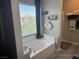 Bright bathroom featuring a soaking tub with a window view and tiled floors at 6867 Dragonfly Rock St, Las Vegas, NV 89148