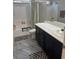 Bathroom featuring a toilet, a double sink vanity with black cabinets, and a shower-tub combo at 6867 Dragonfly Rock St, Las Vegas, NV 89148