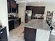 Modern kitchen featuring stainless steel appliances, dark wood cabinets, and a granite-topped island with seating at 6867 Dragonfly Rock St, Las Vegas, NV 89148