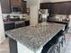 Beautiful kitchen with dark wood cabinets, stainless steel appliances, and granite countertops with seating at 6867 Dragonfly Rock St, Las Vegas, NV 89148