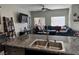 Open floor plan showcasing a living area with a large sofa and a kitchen with granite countertops at 6867 Dragonfly Rock St, Las Vegas, NV 89148