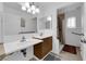Bathroom featuring dual sinks, wood cabinets, large mirrors, and a walk-in shower with grab bars at 781 Bourbon St # 1, Pahrump, NV 89048