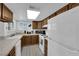 Functional kitchen with white appliances, and ample cabinet space and tile counters at 781 Bourbon St # 1, Pahrump, NV 89048