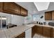 Well-lit kitchen with tile countertops and backsplash, white appliances, and backyard access at 781 Bourbon St # 1, Pahrump, NV 89048