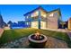 Spacious backyard at dusk features a pool with a glass fence, green grass, and a cozy fire pit at 786 Etter Creek St, Las Vegas, NV 89138