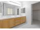 Well-lit bathroom featuring double sinks, light wood cabinets, and a walk-in closet at 820 Peach Ave, North Las Vegas, NV 89032