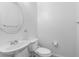 This half bathroom features a toilet, sink, round mirror, and towel rack at 820 Peach Ave, North Las Vegas, NV 89032
