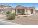 Inviting single-story home boasting desert landscaping, a tile roof, and an attached two-car garage at 820 Peach Ave, North Las Vegas, NV 89032