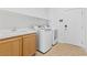 Laundry room with sink, cabinets, front-load washer and dryer, and access door at 820 Peach Ave, North Las Vegas, NV 89032