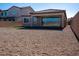 A backyard features a gravel area, a small patch of green turf, and a covered patio area in a neutral color scheme at 832 Gallery Course Dr, Las Vegas, NV 89148