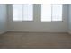 Bright bedroom with neutral carpet and two windows at 832 Gallery Course Dr, Las Vegas, NV 89148