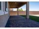 A covered patio features brick style floor, gray columns, and a small patch of grass beyond the patio, creating a cozy outdoor space at 832 Gallery Course Dr, Las Vegas, NV 89148