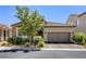 Inviting single-story home featuring a two-car garage, stone accents, and desert landscaping at 832 Gallery Course Dr, Las Vegas, NV 89148