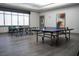 A game room features ping pong tables, large windows, and minimalist decor, ideal for recreational activities and relaxation at 832 Gallery Course Dr, Las Vegas, NV 89148