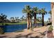 Beautiful golf course with a serene lake, palm trees, and meticulously manicured landscaping at 832 Gallery Course Dr, Las Vegas, NV 89148