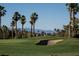 Scenic golf course view with lush green grass, sand trap, and palm trees against a mountain backdrop at 832 Gallery Course Dr, Las Vegas, NV 89148
