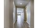 Long hallway with modern tile flooring, bright lighting, and an open view to the living space at 832 Gallery Course Dr, Las Vegas, NV 89148