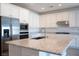 Bright kitchen boasts white cabinets, stainless steel appliances, and a large center island with granite countertops at 832 Gallery Course Dr, Las Vegas, NV 89148