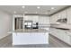 This kitchen features an island with granite countertops, white cabinets, and stainless steel appliances at 832 Gallery Course Dr, Las Vegas, NV 89148