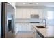 Modern kitchen boasts white cabinetry, stainless steel appliances, and a granite countertop with breakfast bar at 832 Gallery Course Dr, Las Vegas, NV 89148