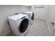 Bright laundry room featuring new, front-loading washer and dryer on tile floors at 832 Gallery Course Dr, Las Vegas, NV 89148