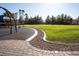 A playground shows a green lawn, trees, a playground set, and a stone paver area, ideal for outdoor fun and recreation at 832 Gallery Course Dr, Las Vegas, NV 89148