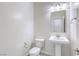 This powder room features a toilet, sink, and light fixture, all in white at 832 Gallery Course Dr, Las Vegas, NV 89148