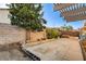 Concrete backyard with block wall, small garden bed, and a tree with minimal landscaping at 8517 Soneto Ln, Las Vegas, NV 89117