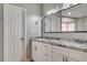 Bathroom featuring a double sink vanity with granite countertop and a large mirror with modern lighting at 8517 Soneto Ln, Las Vegas, NV 89117