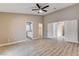 Spacious bedroom with wood-look floors, ceiling fan, and access to an en-suite bathroom and closet at 8517 Soneto Ln, Las Vegas, NV 89117