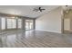Open living room with large windows, sliding glass door, vaulted ceiling, and wood-look floors at 8517 Soneto Ln, Las Vegas, NV 89117