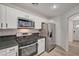Modern kitchen with stainless steel appliances, granite counters, and sleek white cabinetry at 9130 Beauchamp Ave, Las Vegas, NV 89148