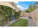 Cozy backyard patio with manicured lawn, decorative rocks, and lush green hedges for privacy at 9256 Blue Flax Pl, Las Vegas, NV 89148