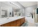 Spacious bathroom with double sink vanity, large mirror, soaking tub, and glass enclosed shower at 9256 Blue Flax Pl, Las Vegas, NV 89148