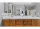 Bright bathroom showcasing double sinks, chrome hardware, vanity, and expansive mirror at 9256 Blue Flax Pl, Las Vegas, NV 89148