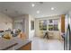 Sunlit kitchen with stainless steel appliances, wood cabinets, breakfast nook, and island at 9256 Blue Flax Pl, Las Vegas, NV 89148